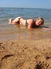 Image showing girl laying on sand at the seacoast