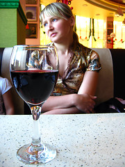 Image showing glass of red wine on the table and a girl