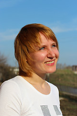 Image showing blue-eyed sympathetic girl looking at the sky