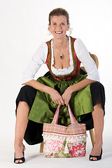 Image showing elderly woman in Bavarian costume dress with bag