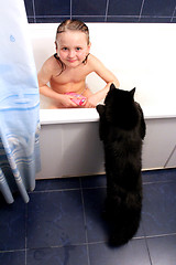 Image showing little girl taking a bath with curious black cat