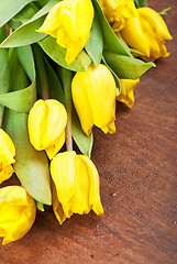 Image showing Yellow tulips on a wooden 