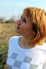 Image showing blue-eyed sympathetic girl looking at the sky