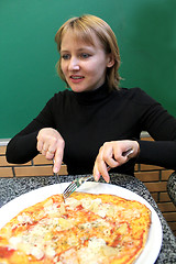 Image showing portrait of sympathetic young woman in pizzeria