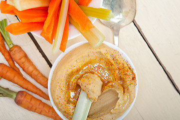 Image showing fresh hummus dip with raw carrot and celery 