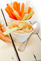 Image showing fresh hummus dip with raw carrot and celery 