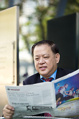 Image showing Asian businessman reading newspaper