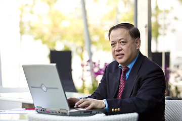 Image showing Asian businessman using laptop