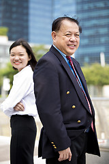 Image showing Asian businessman and young female executive smiling portrait