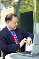 Image showing Asian businessman looking at watch