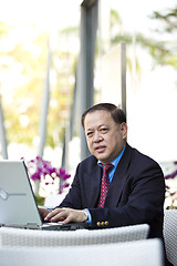 Image showing Asian businessman using laptop