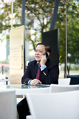 Image showing Asian businessman talking on smart phone