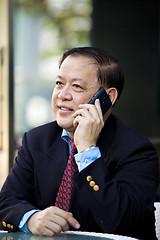 Image showing Asian businessman talking on smart phone