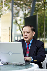 Image showing Asian businessman using laptop