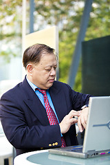 Image showing Asian businessman looking at watch