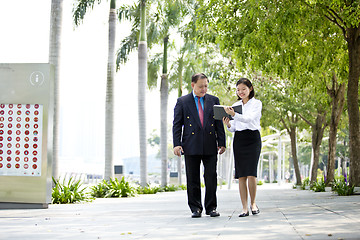 Image showing Asian businessman and young female executive walking together