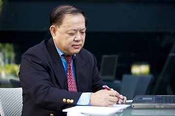 Image showing Asian businessman writing proposal