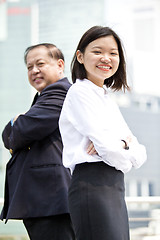 Image showing Asian businessman and young female executive smiling portrait