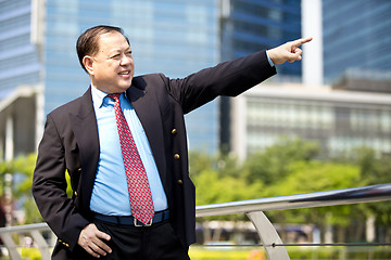 Image showing Asian businessman pointing at a direction