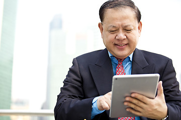 Image showing Asian businessman using tablet