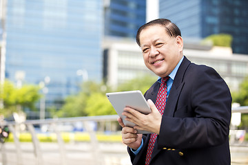 Image showing Asian businessman using tablet