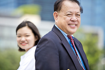 Image showing Asian businessman and young female executive smiling portrait