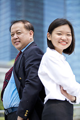 Image showing Asian businessman and young female executive smiling portrait