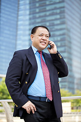 Image showing Asian businessman talking on smart phone