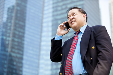 Image showing Asian businessman talking on smart phone