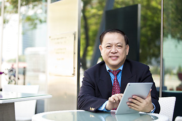 Image showing Asian businessman using tablet