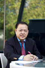 Image showing Asian businessman writing proposal