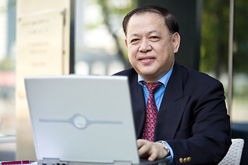 Image showing Asian businessman using laptop