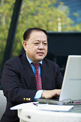 Image showing Asian businessman using laptop