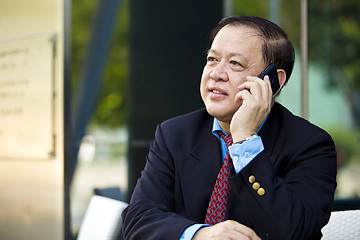 Image showing Asian businessman talking on smart phone