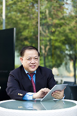 Image showing Asian businessman using tablet