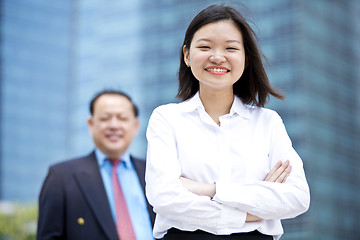 Image showing Asian businessman and young female executive smiling portrait