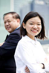 Image showing Asian businessman and young female executive smiling portrait