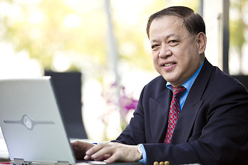 Image showing Asian businessman using laptop