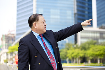 Image showing Asian businessman pointing at a direction