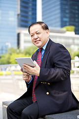 Image showing Asian businessman using tablet