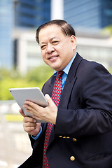 Image showing Asian businessman using tablet