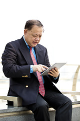 Image showing Asian businessman using tablet