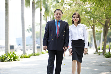 Image showing Asian businessman & young female executive walking