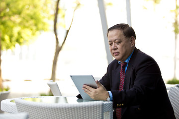 Image showing Asian businessman using tablet