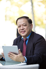 Image showing Asian businessman using tablet