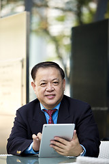 Image showing Asian businessman using tablet