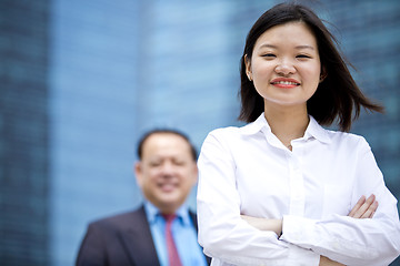 Image showing Asian businessman & young female executive smiling portrait