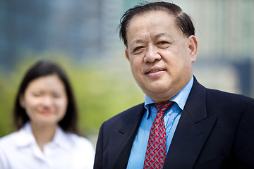 Image showing Asian businessman & young female executive smiling portrait