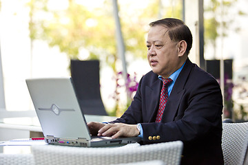 Image showing Asian businessman using laptop