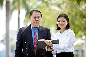 Image showing Asian businessman & young female executive smiling portrait